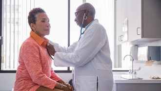 An image of a doctor listening to an older woman's heart.