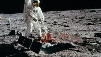 An Apollo 11 astronaut places a seismometer on the surface of the moon.