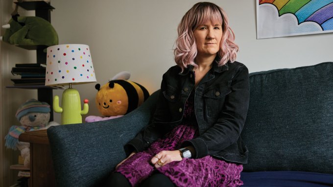 A photo of Amanda sitting on a couch looking at the camera.