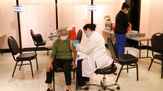 woman receiving a booster shot from a pharmacist